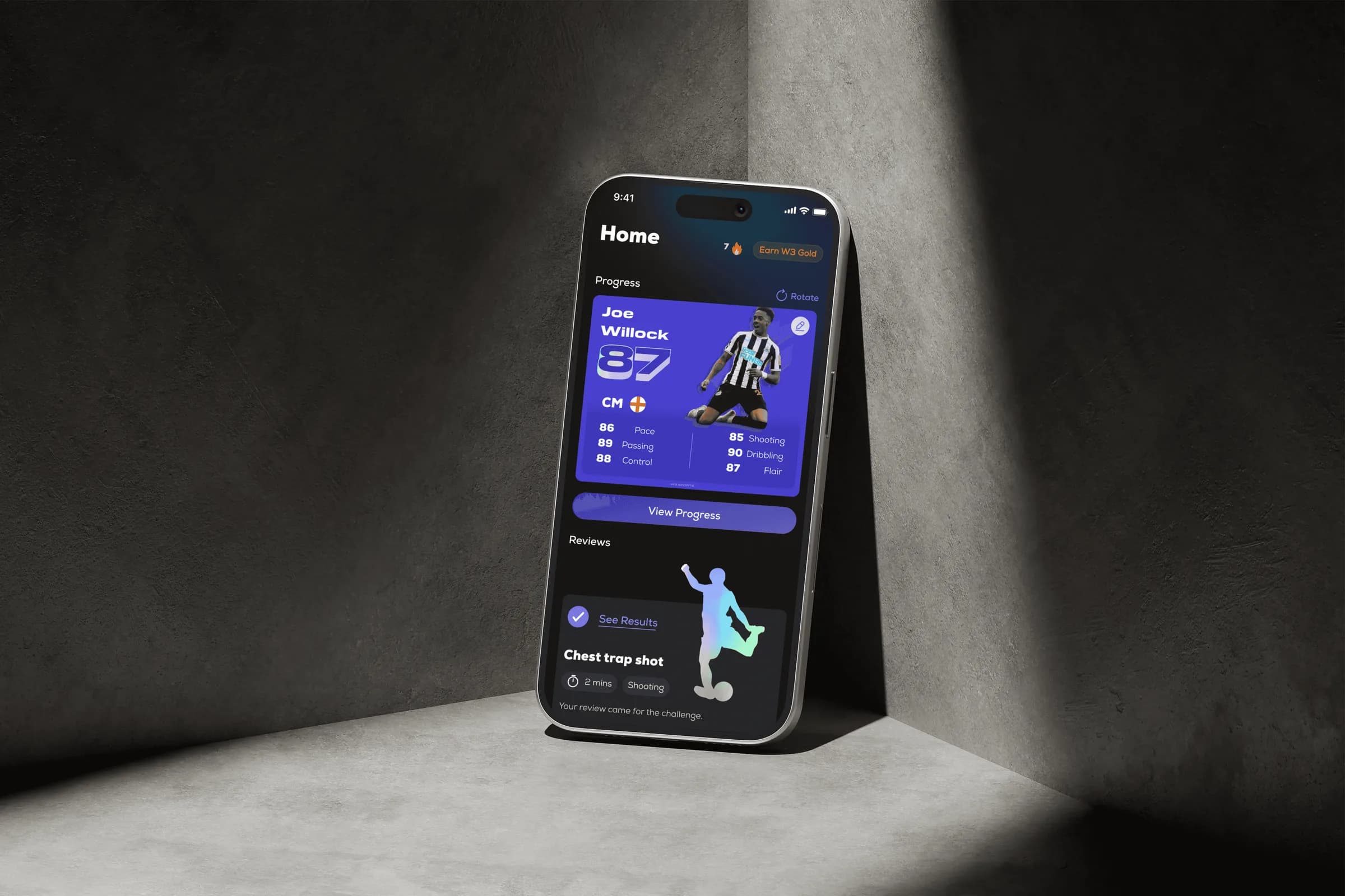Phone leaning against a concrete wall, showing the W3 Sport home screen and player card